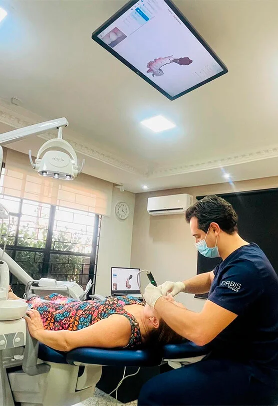 Dr. Michel Moraes atendendo uma paciente com escaneamento digital, acompanhando as imagens na tela